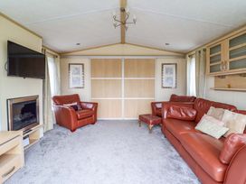 A living room with a television and fireplace at Pemberton Knightsbridge in Morfa Bychan