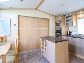 A kitchen with a table and chairs at Pemberton Knightsbridge in Morfa Bychan