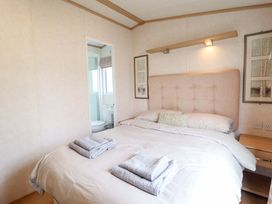 A bedroom with a bed and towels on the bed at Pemberton Knightsbridge in Morfa Bychan