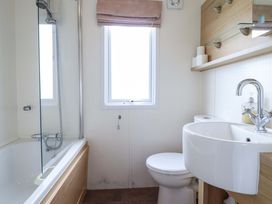 A bathroom with a bathtub and sink at Pemberton Knightsbridge Morfa Bychan