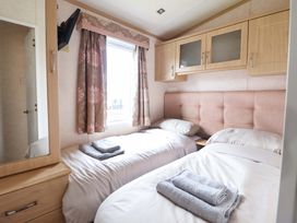 A bedroom with two beds and a mirror at Pemberton Knightsbridge in Morfa Bychan
