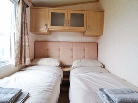 A bedroom with twin beds and wall cabinets at Pemberton Knightsbridge in Morfa Bychan
