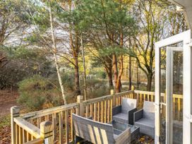 An outdoor area with chairs on decking at Sprindrift - Kelling Heath Holiday Park in Holt