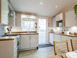 A kitchen with cabinets and appliances at Sprindrift - Kelling Heath Holiday Park in Holt