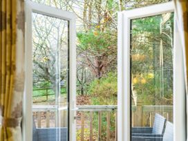 A view from inside through windows to trees outside at Sprindrift - Kelling Heath Holiday Park, Holt