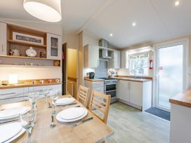 A kitchen with dining table and chairs at Sprindrift - Kelling Heath Holiday Park, Holt
