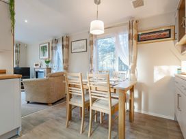 A dining room with a table and chairs at Sprindrift - Kelling Heath Holiday Park in Holt