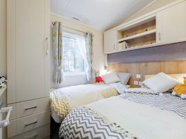 A bedroom with two beds and a window at Sprindrift - Kelling Heath Holiday Park, Holt