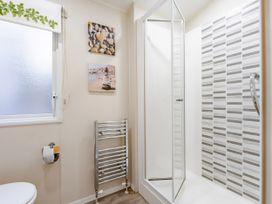 A bathroom featuring a shower and towel rail at Sprindrift - Kelling Heath Holiday Park in Holt