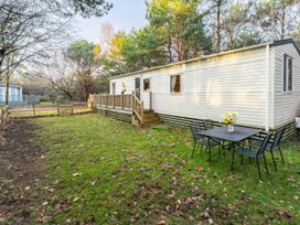A trailer with a deck and seating area at Sprindrift - Kelling Heath Holiday Park in Holt