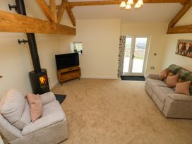 A living room with sofas and a television at Dairy Cottage in Oxwich