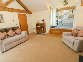 A living room with sofas and a media console at Dairy Cottage in Oxwich
