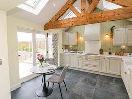 A kitchen with a table and chairs at Dairy Cottage in Oxwich