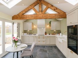 A kitchen with cabinets and a table set at Dairy Cottage in Oxwich