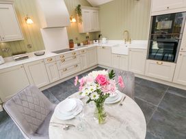 A kitchen with a table and flowers at Dairy Cottage in Oxwich