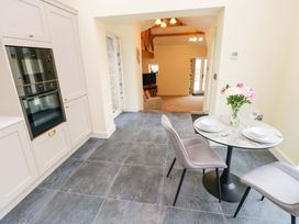A kitchen with a table and chairs at Dairy Cottage in Oxwich