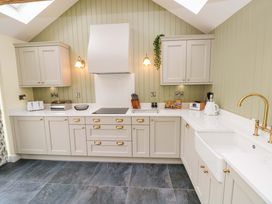A kitchen with cabinets and appliances at Dairy Cottage in Oxwich