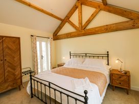 A bedroom with a bed and wardrobe at Dairy Cottage in Oxwich