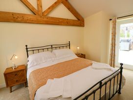 A bedroom with a bed and bedside table at Dairy Cottage in Oxwich