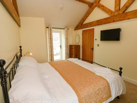 A bedroom with a bed and dressing table at Dairy Cottage in Oxwich