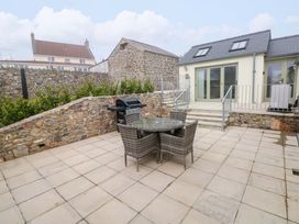 An outdoor patio area with seating and a barbecue grill at Dairy Cottage in Oxwich