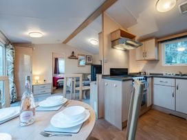 A kitchen with a dining table and chairs at Prima -Kelling Heath Holiday Park in Holt