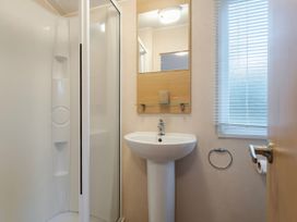 A bathroom with a shower and sink at Prima -Kelling Heath Holiday Park in Holt