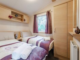A bedroom with two beds and a window at Prima -Kelling Heath Holiday Park in Holt