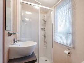 A bathroom with a shower and sink at Prima -Kelling Heath Holiday Park in Holt