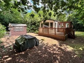 A property with a deck and garden shed at The But n Ben - Kelling Heath Holiday Park in Holt