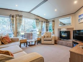 A living room with a sofa and armchair at The But n Ben - Kelling Heath Holiday Park, Holt