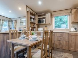 A kitchen with a dining table and chairs at The But n Ben - Kelling Heath Holiday Park, Holt