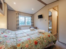 A bedroom with a bed and towels at The But n Ben - Kelling Heath Holiday Park in Holt