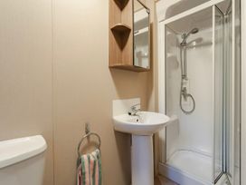 A bathroom with a sink, toilet and shower at The But n Ben - Kelling Heath Holiday Park, Holt
