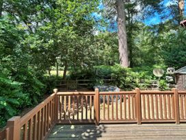 A deck with trees and a shed at The But n Ben - Kelling Heath Holiday Park