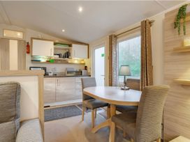 A kitchen with a table and chairs at Rawsons Retreat - Kelling Heath Holiday Park in Holt