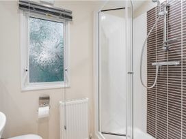 A bathroom with a shower and a toilet at Rawsons Retreat - Kelling Heath Holiday Park, Holt