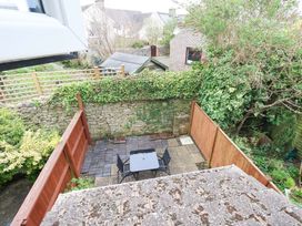 A garden with a table and chairs on paving stones at Amber House, Dorchester