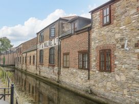 An exterior view of a brick building by a canal at Amber House in Dorchester
