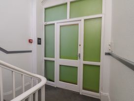 A door with a sign and staircase at Time Out in Whitby