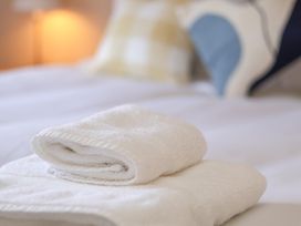 A stack of towels on a bed at Time Out in Whitby