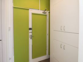 A hallway with a green wall and storage cabinets at Time Out Whitby