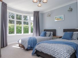 A bedroom with two beds and a nightstand at The Arches in Torquay