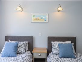 A bedroom with two beds and a nightstand at The Arches in Torquay