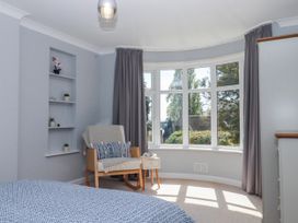 A bedroom with a window and chair at The Arches in Torquay