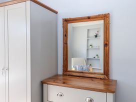 A bedroom with a mirror and wardrobe at The Arches in Torquay