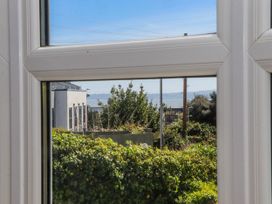 A view from a window showing greenery and buildings at The Arches in Torquay