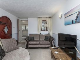 A living room with a sofa and television at Preswylfa 