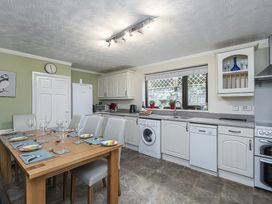 A kitchen with table and chairs at Preswylfa