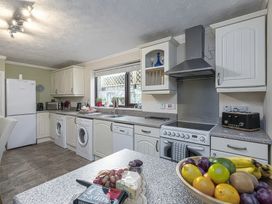 A kitchen with appliances and a fruit bowl at Preswylfa